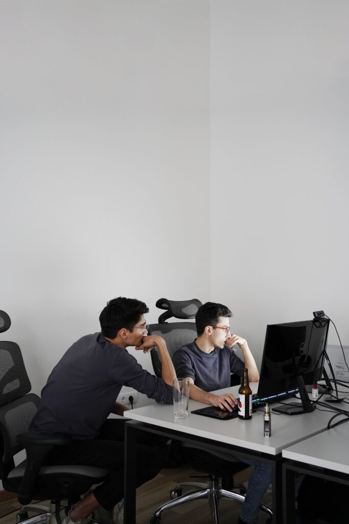 2 men sitting on black office rolling chairs photo