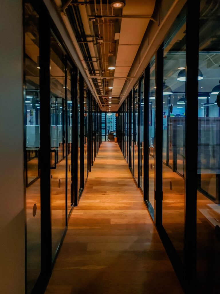 Glass paneled long wooden floored hallway photo